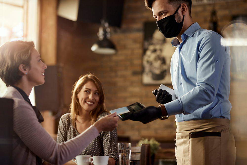 Waiter taking payment in restaurant